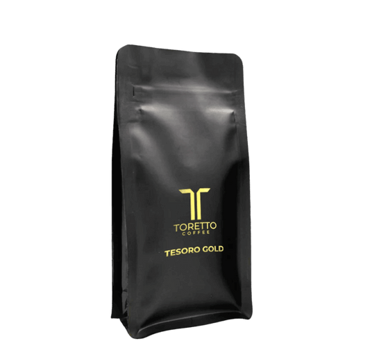 Package of Tesoro Gold coffee with notes of chocolate, caramel, and plum, promising a luxurious and bold coffee experience.